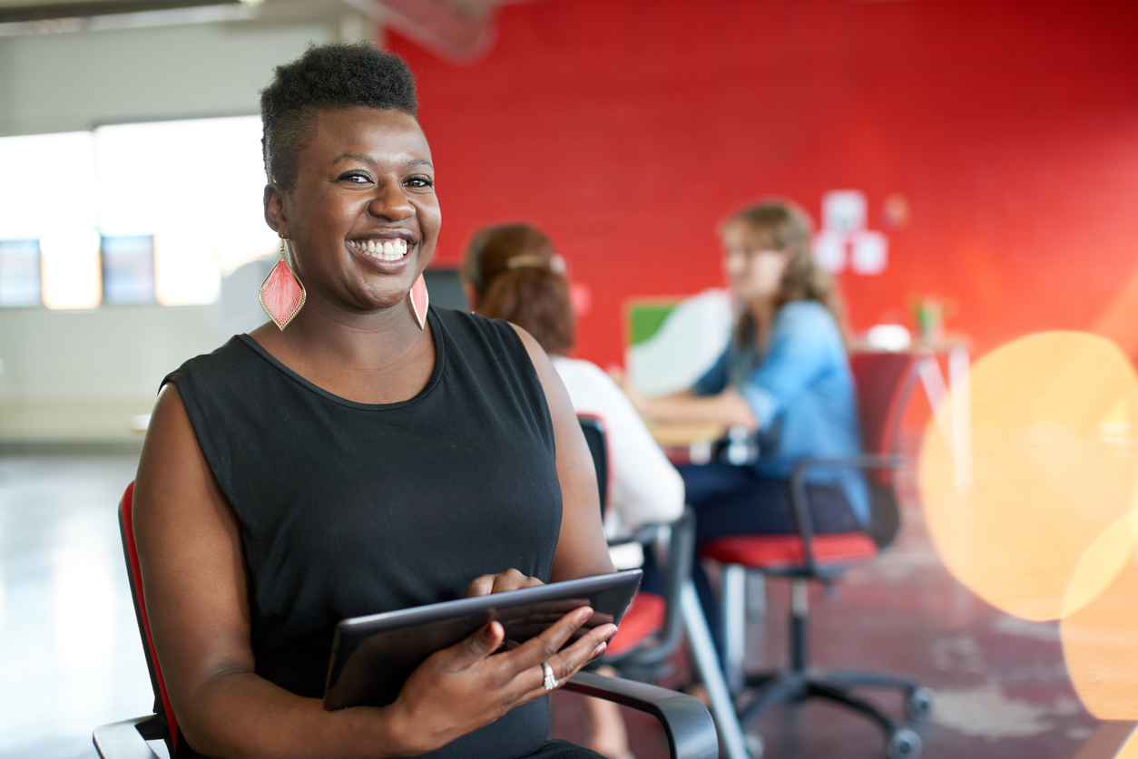 Confident female designer working on a digital tablet in red